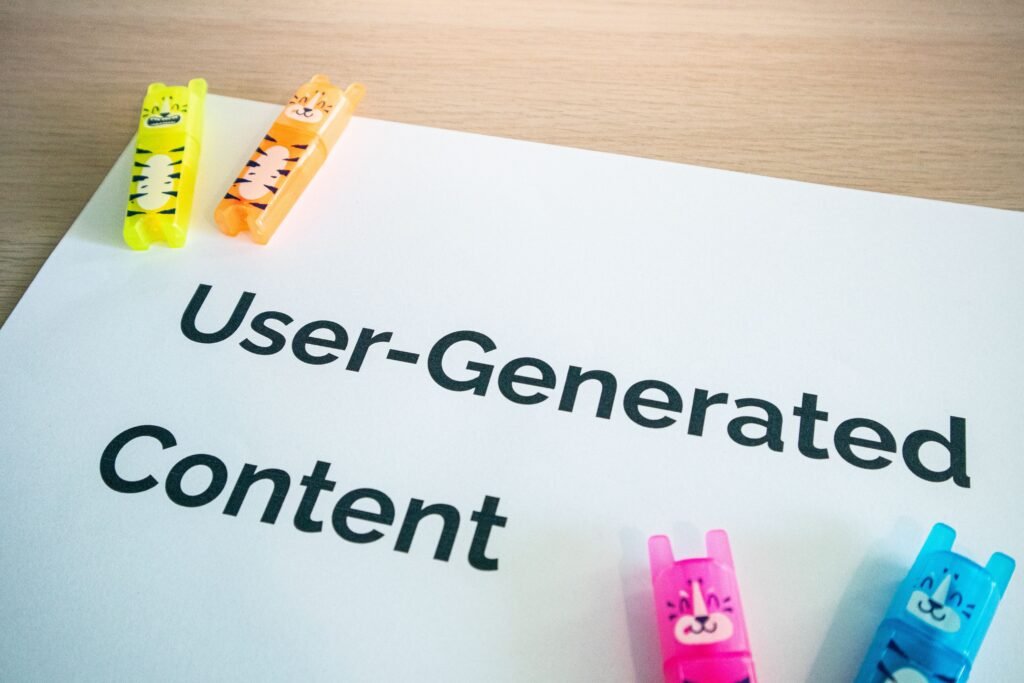 Bright highlighters on a 'User-Generated Content' note against a wooden desk.